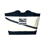 Black and white bag with 'Playwear Remade in Nova Scotia' logo on a white background